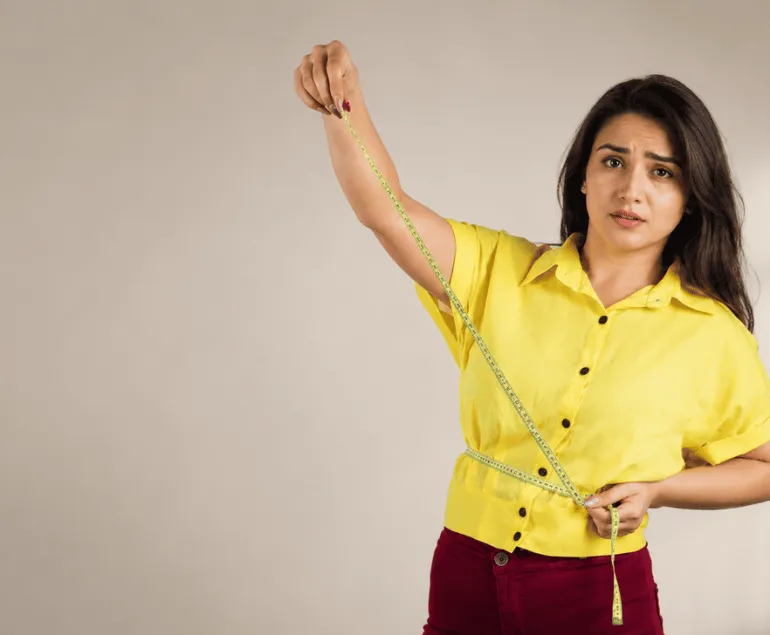 Indian-woman-measuring-waist-with-tape