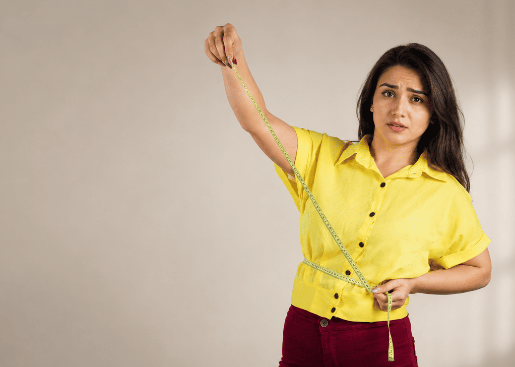 Indian-woman-measuring-waist-with-tape